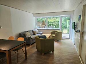 a living room with a couch and chairs and a table at Drømmehus Ferienwohnungen in Nørre Nebel
