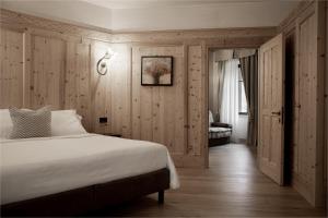 a bedroom with a large white bed and a couch at Hotel Orso Grigio in Cavalese