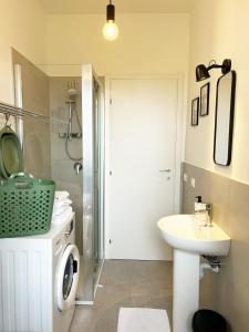 a bathroom with a sink and a washing machine at Quick Home Belvedere Masserano in Masserano +34 photos