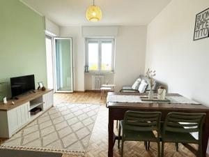 a living room with a dining table and a television at Quick Home Belvedere Masserano in Masserano