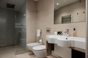 a bathroom with a sink and a toilet and a shower at Hotel Orso Grigio in Cavalese +50 photos