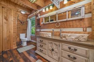 a bathroom with two sinks and a toilet in a log cabin at Tranquility Cove Lodge in Dandridge +65 photos