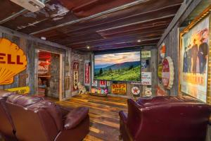 a room with two leather chairs and a large screen at Tranquility Cove Lodge in Dandridge
