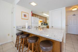 a kitchen with a counter and bar stools at Driftwood Towers 5E in Gulf Shores