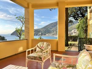 a porch with two chairs and a view of the ocean at VILLA TRAMONTO in Levanto