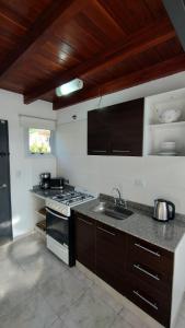 a kitchen with a stove and a sink in it at Paititi Loft - Solo Adultos in Villa Carlos Paz