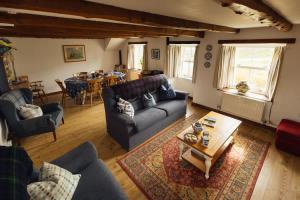 a living room with a couch and a table at Charming Upper Solva Cottage by Beaches and Harbour in Solva