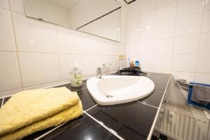 a white bathroom with a sink and a mirror at Appartement Denis in Chemnitz