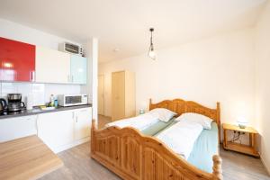 a bedroom with a wooden bed in a kitchen at Appartement Denis in Chemnitz