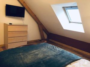 a bedroom with a skylight and a bed and a tv at Parfums des peintres proche Crozant - Chambres d'hôtes in Villard