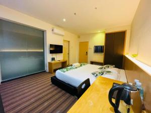 a hotel room with a bed and a desk at Melaka City Hotel in Malacca