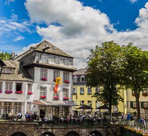 un gruppo di edifici vicino a un fiume di Horchem Hotel-Restaurant-Café-Bar a Monschau