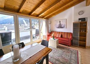 a living room with a red couch and a table at Appartements am Kirchplatz in Fulpmes