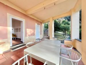 a dining room with a white table and chairs at VILLA TRAMONTO in Levanto