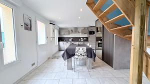 a dining room with a table and a kitchen at Le Nid Des Grands Geais in Le Crotoy
