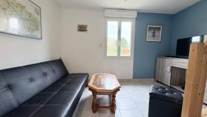 a living room with a couch and a coffee table at Le Nid Des Grands Geais in Le Crotoy