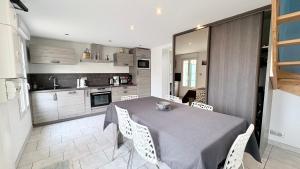 a kitchen and dining room with a table and chairs at Le Nid Des Grands Geais in Le Crotoy +4 photos