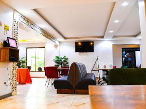 a lobby with a couch and a table and chairs at Decale Jewel Stone Hotel in Nairobi