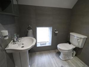 a bathroom with a sink and a toilet and a window at Orchard View in Alfreton +15 photos