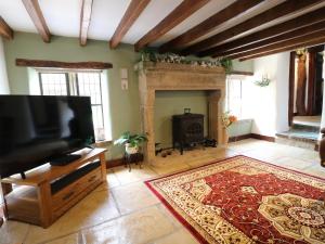 a living room with a fireplace and a flat screen tv at Orchard View in Alfreton