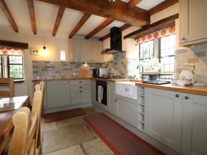a kitchen with white cabinets and a table at Orchard View in Alfreton