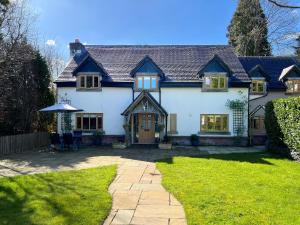 a large white house with a patio in the yard at The Oaks in Blackburn