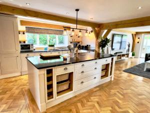 a large kitchen with white cabinets and a large island at The Oaks in Blackburn