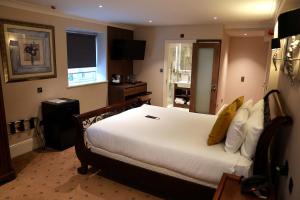 a bedroom with a large white bed in a room at The Tudor Hotel in Harrow
