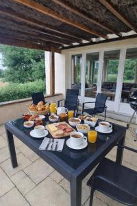 a table with food and drinks on a patio at Parfums des peintres proche Crozant - Chambres d'hôtes in Villard