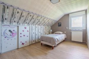 a bedroom with a bed and a wall with butterflies at La Clairière de Dogneville - proche Epinal in Dogneville +6 photos