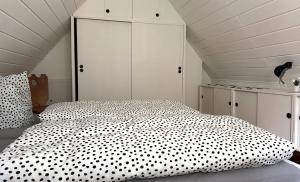 a bedroom with a white bed with black polka dots at Waldhaus zur Kleinbahn in Glashütte