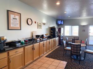 a kitchen with wooden cabinets and a table and a refrigerator at Horizon Hotel in Vernal