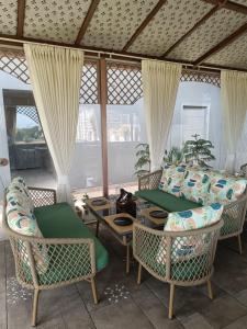 a porch with chairs and a couch and a table at Hotel Luxe Manor in Mohali