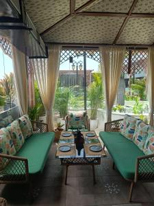 a porch with green furniture and a table at Hotel Luxe Manor in Mohali