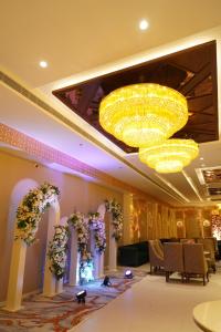 a banquet hall with a large chandelier and flowers at Hotel Luxe Manor in Mohali