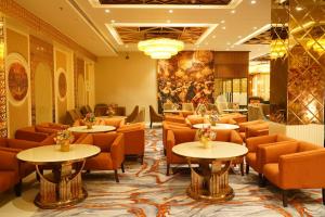 a restaurant with tables and chairs and a painting on the wall at Hotel Luxe Manor in Mohali