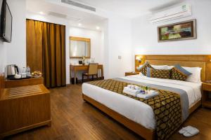 a hotel room with a large bed and a desk at Rahitya Premier in New Delhi