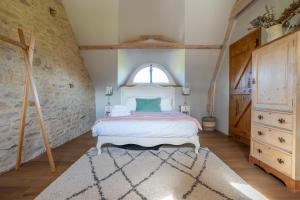 a bedroom with a bed and a large window at Ty Bras - 8000 m² de jardin in Camors