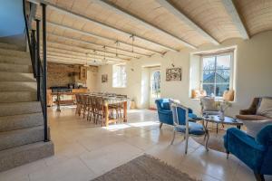 a living room with blue chairs and a table at Ty Bras - 8000 m² de jardin in Camors
