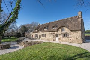 an old stone house with a thatched roof at Ty Bras - 8000 m² de jardin in Camors