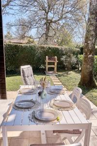 a white picnic table with plates on top of it at Chalet Solariale in La Teste-de-Buch