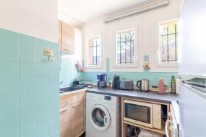 a kitchen with a washing machine and a microwave at Le cocon de Boutiny - à Peymeinade in Peymeinade +4 photos