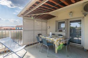 a patio with a table and chairs on a balcony at Le cocon de Boutiny - à Peymeinade in Peymeinade