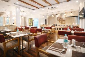 a dining room with tables and chairs and a restaurant at Rahitya Premier in New Delhi