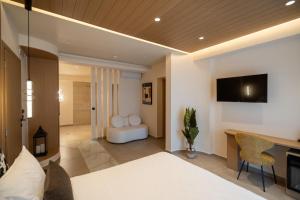 a bedroom with a bed and a desk and a television at Dea Rethymno in Rethymno