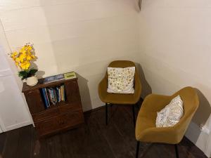 a room with two chairs and a table with a vase of flowers at La Kaz Yab in Salazie