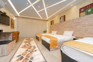 a hotel room with two beds and a flat screen tv at pyramids view suite/vista piramidi in Cairo