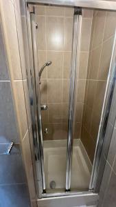 a shower with a glass door in a bathroom at Sangha Hall - Private Ensuite Rooms with Shared Kitchen in Leicester +69 photos