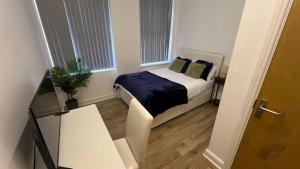 a small bedroom with a bed and a potted plant at Sangha Hall - Private Ensuite Rooms with Shared Kitchen in Leicester