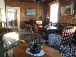 a living room with wooden walls and tables and chairs at Bygdin Høyfjellshotell in Beitostøl